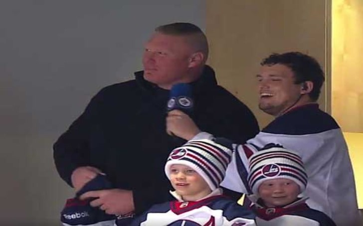 Turk Lesnar in a white cap and blue and white uniform with his brother and father in black jacket.